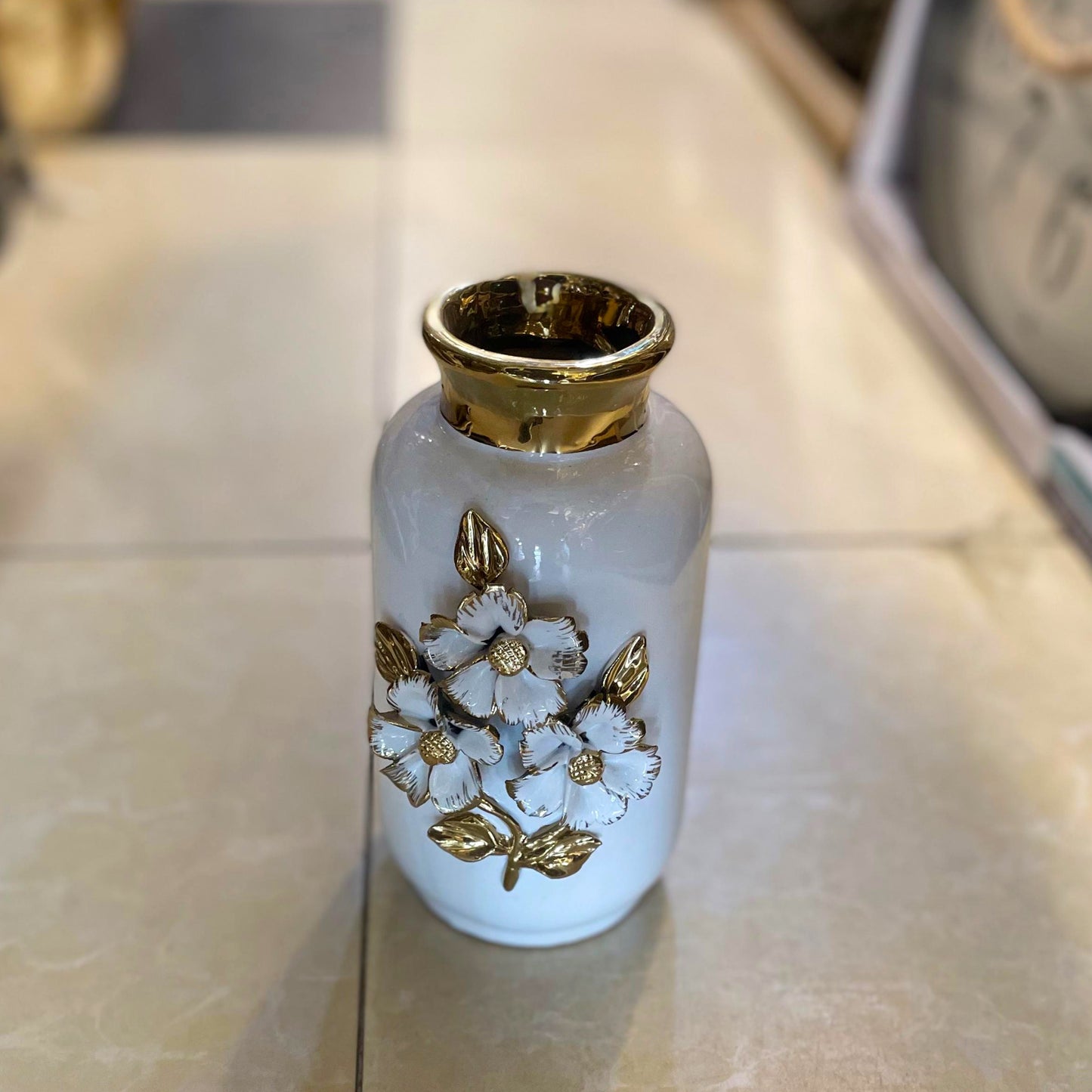 white ceramic flower vase accented with luxurious gold detailing and 3D floral